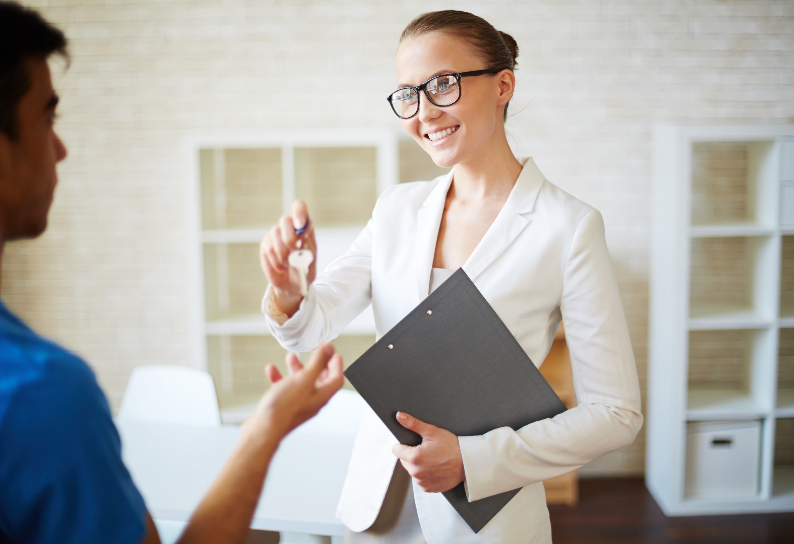 Successful woman passing key to her client